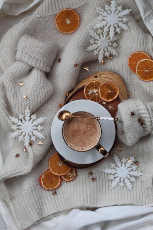 Free Top View of a Cup of Hot Chocolate and Lemon Slices on a White Sweater Stock Photo